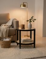 Manila Side Table. Modern minimalism. Black elm wood frame. Clean lines. Rounded corners. Clear glass top. Natural cane open weave. Organic appeal. Sustainable frame. Natural rattan weave. Organic simplicity. Mid-century modern. Stylish. Functional. Living room. Hallway. Bedroom. Durable. Elegant design.