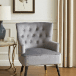 Tufted grey upholstery. Luxe chairs. Contemporary design. Plush cushioning. Boutique style. Gold finish tipped feet. Living room. Furniture. Home decor. Seating. Statement piece. Elegant. Comfortable. Stylish. Durable. High-quality materials. Modern classic. Sophisticated. Black legs. Gold tips. Unique design. Versatile. Timeless. Eye-catching. Velvet. Mira.