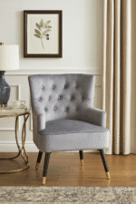 Tufted grey upholstery. Luxe chairs. Contemporary design. Plush cushioning. Boutique style. Gold finish tipped feet. Living room. Furniture. Home decor. Seating. Statement piece. Elegant. Comfortable. Stylish. Durable. High-quality materials. Modern classic. Sophisticated. Black legs. Gold tips. Unique design. Versatile. Timeless. Eye-catching. Velvet. Mira.