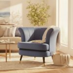 Emilia velvet chair. Scalloped accent chair. Velvet upholstery. Luxe chair. Gold finish legs. Black wood legs. Blue velvet. Pink velvet. Grey velvet. Mink velvet. Plush cushioning. Boutique style. Contemporary chair. Stylish seating. Home furniture. Living room chair. Decorative chair. Elegant furniture. Modern accent chair. Trendy home decor. Comfortable seating. Luxury chair. Designer chair.