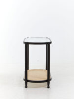 Elm wood. Console table. Modern minimalism. Black finish. Clean lines. Rounded corners. Clear glass top. Lower shelf. Natural cane. Open weave. Sustainable frame. Natural rattan. Organic simplicity. Mid-century modern. Stylish. Functional. Living room. Hallway. Entryway. Durable. Elegant design. Furniture. Home. Display.