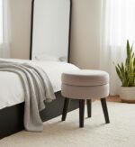 Lila footstool. Velvet footstool. Upholstered footstool. Luxury footstool. Modern footstool. Plush footrest. Boutique furniture. Blue footstool. Grey footstool. Mink footstool. Burgundy footstool. Wine red footstool. Velvet furniture. Contemporary footstool. Small ottoman. Velvet ottoman. Stylish footstool. Soft seating. Home accessories. Bedroom furniture. Living room furniture. Accent furniture. Modern interior. Black wooden legs. Cushioned stool. Velvet accent piece. Compact seating solution.