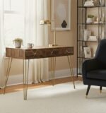 Talia desk. Mid-century modern desk. Wood veneer desk. Writing desk. Home office furniture. Stylish desk. Modern desk. Three drawer desk. Hairpin leg desk. Wooden desk. Contemporary furniture. Retro desk. Brown desk. Compact home desk. Warm metallic legs. Desk with storage. Vintage style desk. Small office desk. Wooden home office furniture. Metal leg desk. Storage solution. Classic desk design. Home study furniture. Workspace furniture. Rustic finish desk.