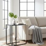 Axel Side Table. C-shaped side table. Black side table. Grey side table. Powder-coated metal. Modern side table. Minimalist furniture. Lightweight table. Living room furniture. Sofa side table. Contemporary home decor. Metal side table. Sleek design. Open sledge base. Durable side table. Small side table. Compact furniture. Space-saving table. Elegant side table. Home accessories.