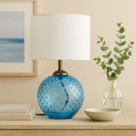 Home. Lighting. Table Lamp. Glass Lamp. Dimpled Glass. Modern Lighting. Contemporary Decor. Ambient Lighting. Accent Lighting. Fabric Shade. Gold Finish. Glass Base. Cylinder Shade. Grey Lamp. Aqua Blue Lamp. Clear Glass Lamp. Elegant Lamp. Bedroom Lighting. Living Room Lighting. Office Lighting. Luxe Lighting. Interior Styling. Soft Glow Lamp. Decorative Lighting. Minimalist Lamp. Translucent Lamp