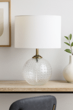 Home. Lighting. Table Lamp. Glass Lamp. Dimpled Glass. Modern Lighting. Contemporary Decor. Ambient Lighting. Accent Lighting. Fabric Shade. Gold Finish. Glass Base. Cylinder Shade. Grey Lamp. Aqua Blue Lamp. Clear Glass Lamp. Elegant Lamp. Bedroom Lighting. Living Room Lighting. Office Lighting. Luxe Lighting. Interior Styling. Soft Glow Lamp. Decorative Lighting. Minimalist Lamp. Translucent Lamp