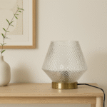 Vira Table Lamp. Glass table lamp. Embossed glass. Textured glass lamp. Gold finish base. Grey lamp. Aqua blue lamp. Clear lamp. Contemporary lighting. Modern table lamp. Home lighting. Ambient lighting. Decorative lamp. Living room lighting. Bedroom lighting. Stylish lamp. Metallic gold lamp. Interior decor. Lighting fixture.