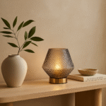 Vira Table Lamp. Glass table lamp. Embossed glass. Textured glass lamp. Gold finish base. Grey lamp. Aqua blue lamp. Clear lamp. Contemporary lighting. Modern table lamp. Home lighting. Ambient lighting. Decorative lamp. Living room lighting. Bedroom lighting. Stylish lamp. Metallic gold lamp. Interior decor. Lighting fixture.