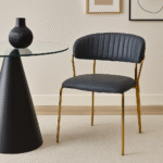 Taryn Faux Leather Dining Chair. Dark grey dining chair. Faux leather dining chair. Modern dining chair. Gold leg dining chair. Contemporary dining furniture. Padded dining chair. Tufted backrest chair. Minimalist dining chair. Ergonomic dining seating. Luxury grey dining chair. Easy clean faux leather chair. Metal frame dining chair. Stylish kitchen chair. Modern home office chair. Compact dining chair. Gold finish legs chair. Soft padded dining chair. Industrial modern chair. Elegant dining room seating.