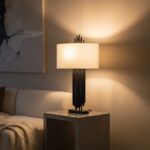 home. lighting. table lamp. contemporary design. modern lighting. sculptural lamp. asymmetric lamp. black lamp. gold lamp. fabric shade. linen shade. ambient lighting. decorative lighting. iron lamp. minimalist decor. living room lighting. bedroom lighting. stylish home accessories. modern table lamp. Avela lamp. home accents.