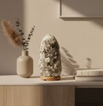 Avelina salt lamp. Grey salt lamp. Natural salt lamp. Calming light. Wood base lamp. Modern salt lamp. Decorative lighting. Wellness decor. Ambient light. Oblong salt lamp. Grey crystal lamp. Natural decor. Meditation light. Himalayan style lamp. Bedroom lighting. Boho home accessories. Soft glow lamp. Nature-inspired lighting. Handcrafted lamp. Zen home accents.