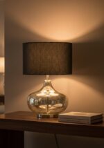 Verina table lamp. silver glass lamp. black linen shade. gourd style lamp. ambient lighting. modern table lamp. contemporary lighting. decorative lamp. bedside lamp. desk lamp. stylish lamp. compact lighting. luxury table lamp. silver finish. glass body lamp. round metal base. soft glow lamp. living room lighting. bedroom lighting. office lamp. minimalist lighting. transitional décor. home accessories. interior lighting. designer lamp.