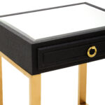 Cardoba Shagreen Bedside Table. Black shagreen leather. Gold U-shaped legs. Knocker-style handle. Modern nightstand. Luxury bedside table. Contemporary furniture. Textured finish. Durable frame. Boutique bedroom décor.