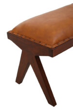 Cadenza Bench With Inverted Base. Tan leather bench. Teak wood base. Inverted V legs. Genuine leather upholstery. Nail head trim. Rustic modern bench. Luxury accent seating. Handcrafted furniture. Vintage-inspired design.