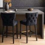 Amani Bar Stool. Black fabric bar stool. Upholstered stool. Rubberwood legs. Modern bar seating. Padded bar stool. Contemporary bar furniture. Metal footrest stool. Scandinavian style seating. Minimalist design.