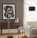 Syra Floor Lamp. Arched Brass Floor Lamp. Black Marble Base Lamp. Black Fabric Shade Lamp. Contemporary Floor Lamp. Modern Home Lighting. Reading Floor Lamp. Ambient Lighting Feature. Boutique Style Lamp. Luxury Floor Lamp. Statement Lighting. Living Room Floor Lamp. Bedroom Floor Lamp. Elegant Home Lighting. Antique Brass Finish Lamp.