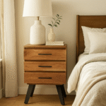 Zuri Acacia Bedside Table. Acacia wood furniture. Black metal legs. Industrial bedside table. Three drawer nightstand. Modern bedroom storage. Contemporary side table. Durable wooden furniture. Minimalist bedside unit. Natural wood design.