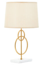 Raya Gold Circles Table Lamp. Gold table lamp. White marble base lamp. Beige linen shade lamp. Art deco lighting. Modern gold lamp. Luxury table light. Elegant bedside lamp. Contemporary lighting design. Sculptural metal lamp. Living room lighting. Bedroom table lamp. Marble and gold décor. Boutique home accessory. Ambient light fixture. Minimalist table lamp. Designer home lighting. Statement lamp design. Modern art deco décor.