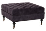 Naya Velvet Ottoman. Dark grey velvet ottoman. Velvet footstool. Tufted velvet ottoman. Chesterfield style ottoman. Luxury ottoman seat. Modern velvet furniture. Grey velvet footrest. Living room ottoman. Plush velvet accent. Castor wheel ottoman. Padded velvet stool. Elegant grey ottoman. Contemporary velvet décor.