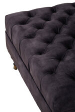 Naya Velvet Ottoman. Dark grey velvet ottoman. Velvet footstool. Tufted velvet ottoman. Chesterfield style ottoman. Luxury ottoman seat. Modern velvet furniture. Grey velvet footrest. Living room ottoman. Plush velvet accent. Castor wheel ottoman. Padded velvet stool. Elegant grey ottoman. Contemporary velvet décor.