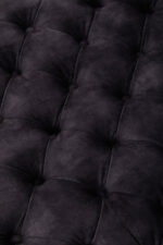 Naya Velvet Ottoman. Dark grey velvet ottoman. Velvet footstool. Tufted velvet ottoman. Chesterfield style ottoman. Luxury ottoman seat. Modern velvet furniture. Grey velvet footrest. Living room ottoman. Plush velvet accent. Castor wheel ottoman. Padded velvet stool. Elegant grey ottoman. Contemporary velvet décor.