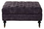 Naya Velvet Ottoman. Dark grey velvet ottoman. Velvet footstool. Tufted velvet ottoman. Chesterfield style ottoman. Luxury ottoman seat. Modern velvet furniture. Grey velvet footrest. Living room ottoman. Plush velvet accent. Castor wheel ottoman. Padded velvet stool. Elegant grey ottoman. Contemporary velvet décor.