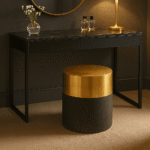 Corina Round Shagreen Stool. Round shagreen stool. Luxury accent stool. Black and gold stool. Textured leather stool. Modern footstool. Art deco stool. Bedroom accent stool. Living room stool. Boutique style furniture. Luxury seating. Contemporary home furniture. Designer stool. Metallic base stool. Compact accent furniture.