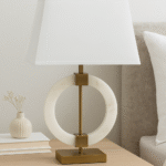 Halden Circular Marble Table Lamp. White marble lamp. Gold base table lamp. Modern marble lighting. Luxury home décor. Brushed gold lamp base. Ivory fabric shade. Contemporary lighting. Sculptural marble lamp. Designer bedside lamp. Elegant living room lighting.