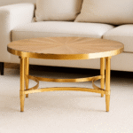 June Coffee Table. Coffee table with curved frame. Aged fir wood table. Gold metal base table. Round coffee table. Sculptural base table. Modern rustic coffee table. Transitional furniture. Luxury living room table. Contemporary coffee table. Curved design furniture. Gold accent table. Fir wood and metal coffee table. Elegant round table. Statement living room décor. Designer coffee table. Artful furniture design. Warm metallic finish table. Stylish home accent. Minimalist modern furniture.