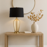 Malden Amber Glass Table Lamp. Amber glass table lamp. Gold base table lamp. Black fabric shade lamp. Luxury glass lighting. Modern amber lamp. Elegant bedside lamp. Contemporary table lamp. Living room lighting. Designer glass lamp. Warm glow lamp. Gold and black table lamp. Sculptural glass base lamp. Decorative lighting. Luxury home décor. Modern classic table lamp. Stylish desk lamp. Glass and metal lamp. Ambient lighting solution. Boutique home lighting.