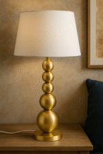 Rae Stacked Table Lamp. Brass table lamp. Orb base lamp. Modern lighting. Luxe home décor. Boutique-style lamp. White linen shade. Contemporary bedside light. Sculptural design lamp. Gold Table Lamp.