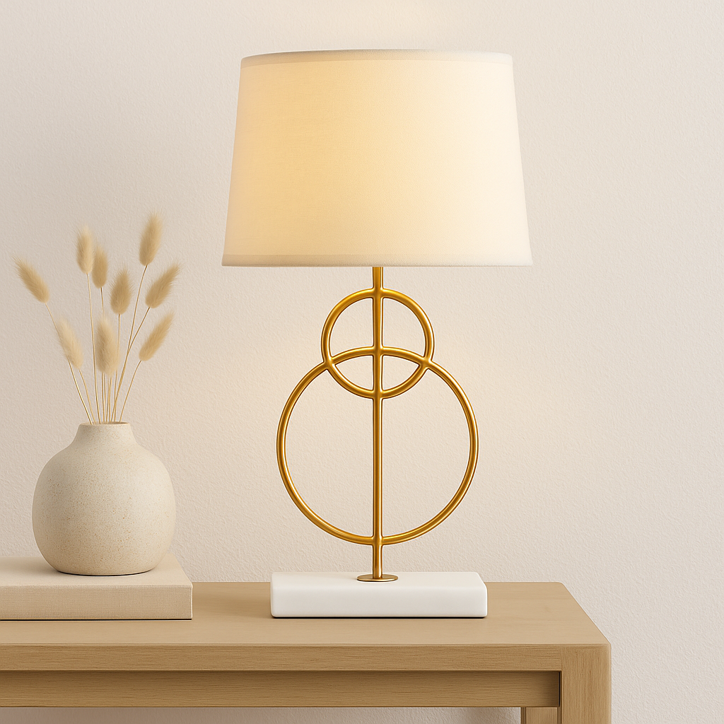 Raya Gold Circles Table Lamp Raya Gold Circles Table Lamp. Gold table lamp. White marble base lamp. Beige linen shade lamp. Art deco lighting. Modern gold lamp. Luxury table light. Elegant bedside lamp. Contemporary lighting design. Sculptural metal lamp. Living room lighting. Bedroom table lamp. Marble and gold décor. Boutique home accessory. Ambient light fixture. Minimalist table lamp. Designer home lighting. Statement lamp design. Modern art deco décor.